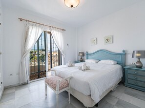 A bedroom with a bed, a chair, a nightstand, and a lamp. - Fuentesol 15 Casa Lindblad by Casasol by Interhome (Nerja)