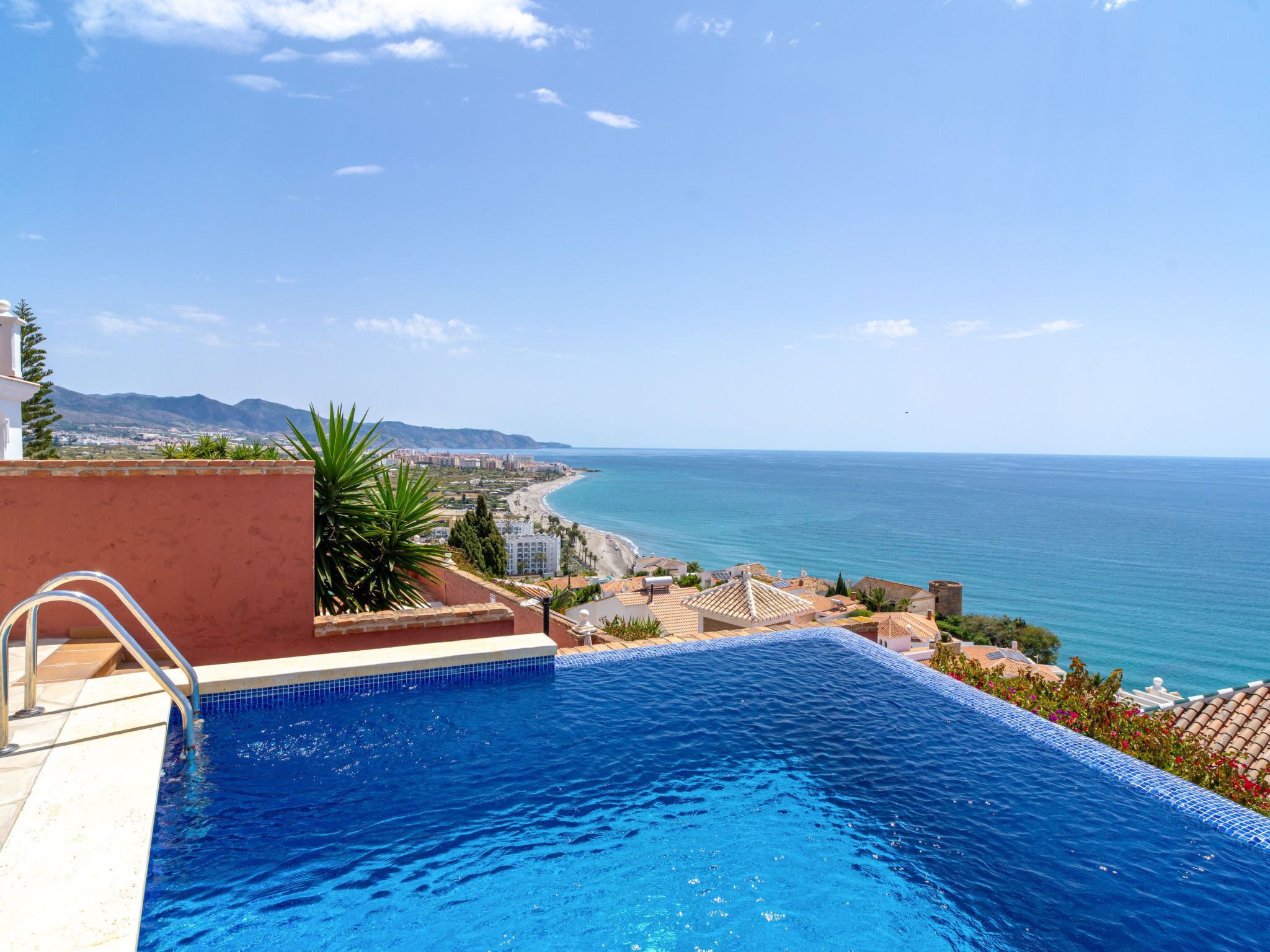 A swimming pool with a view of the sea and a coastal town.