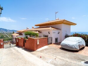 A two-story house with a tiled roof, a covered carport, and a view of the sea. - Villa Prime Seaview by Casasol by Interhome (Nerja)