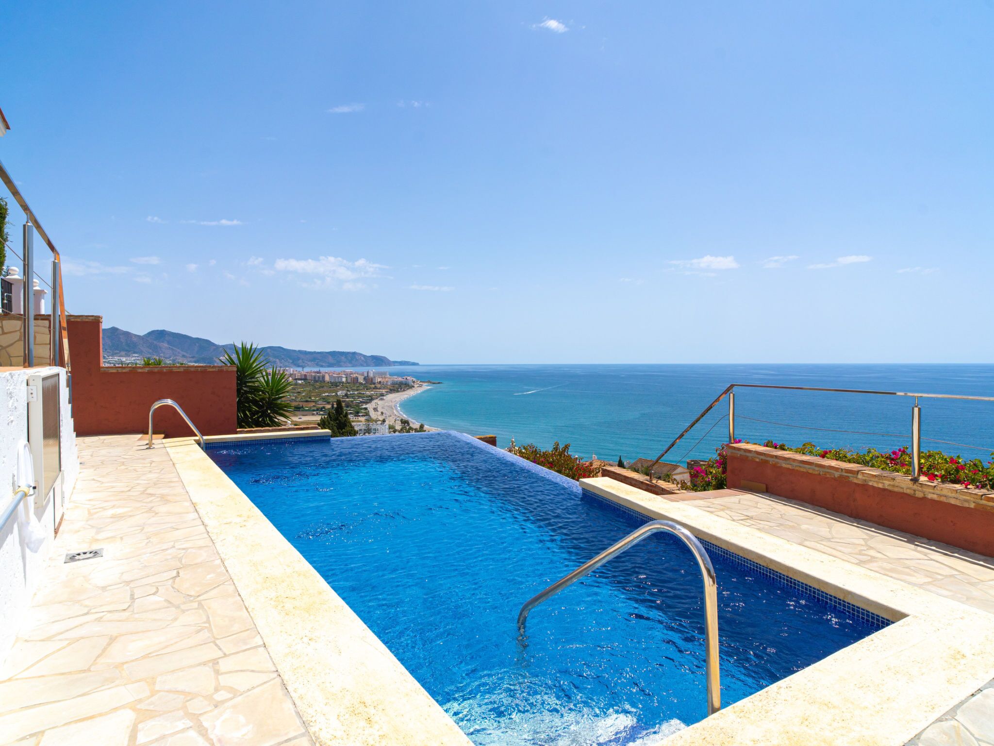 Ein Schwimmbad mit Blick auf das Meer und die Berge.