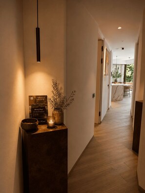 A hallway with a reception desk, a hanging light fixture, and a view into a dining area. - NEW: Casa Jasmina - Residence Corte Carden 2 (Bardolino)
