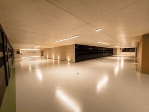 A spacious, well-lit indoor area with a long corridor and a row of closed lockers on one side. - NEW: Casa Jasmina - Residence Corte Carden 2 (Bardolino)