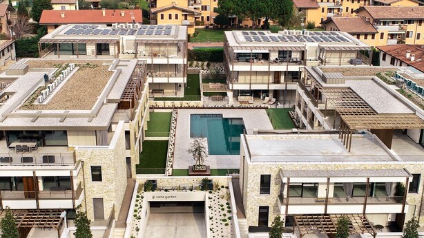 Un complesso residenziale moderno con diversi edifici, un cortile interno e una piscina.