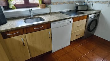 Een keuken met een spoelbak, vaatwasser en wasmachine.