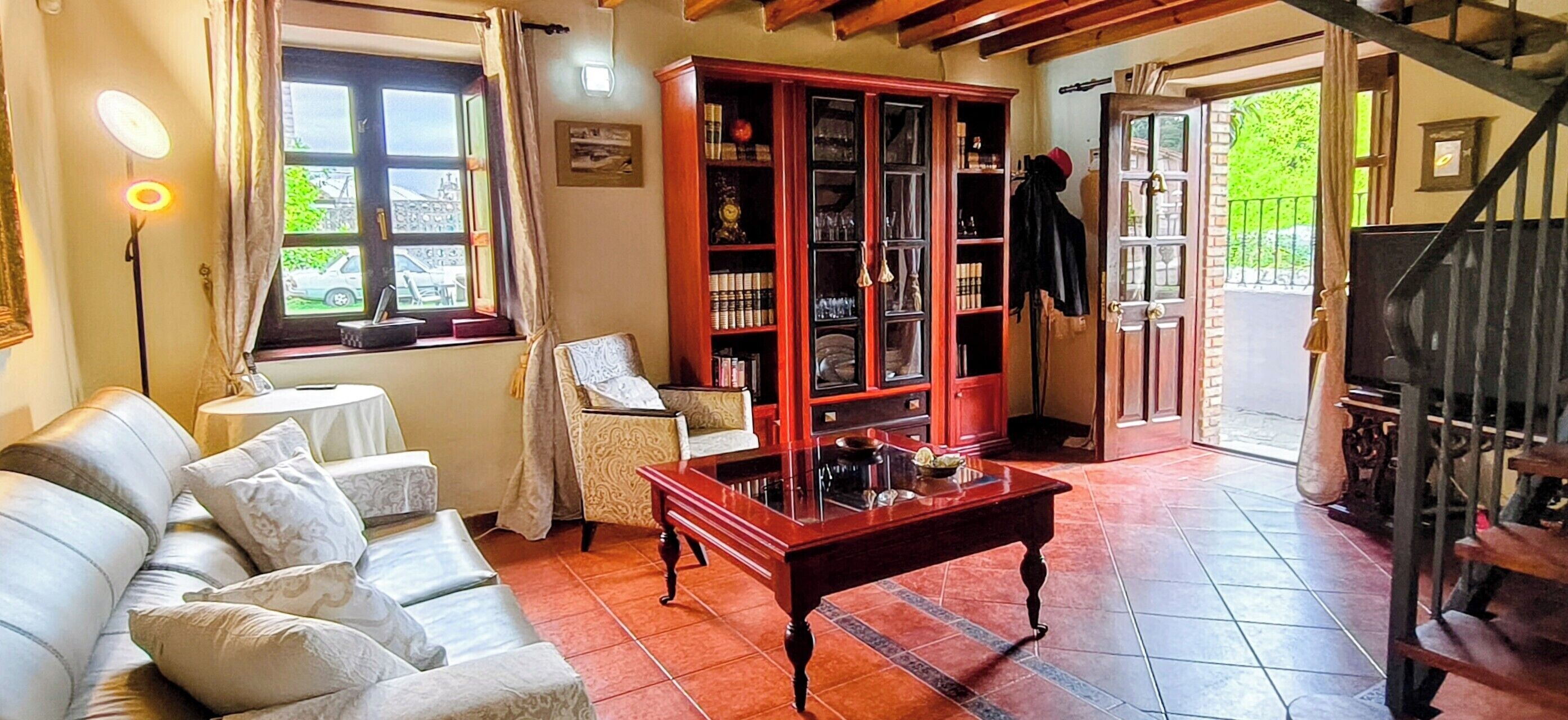 Une pièce comprenant un canapé, un meuble en bois, une table et un escalier.