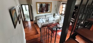 A living room with a sofa, a coffee table, and a staircase.