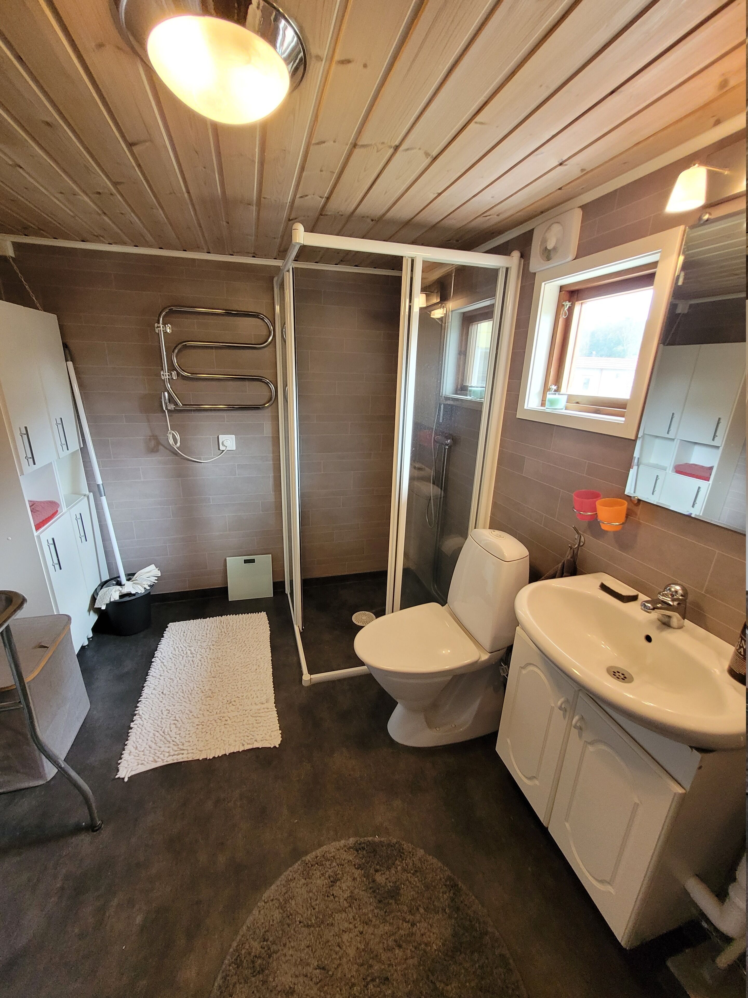 Une salle de bain équipée d’une douche, de toilettes, d’un lavabo et d’un miroir.