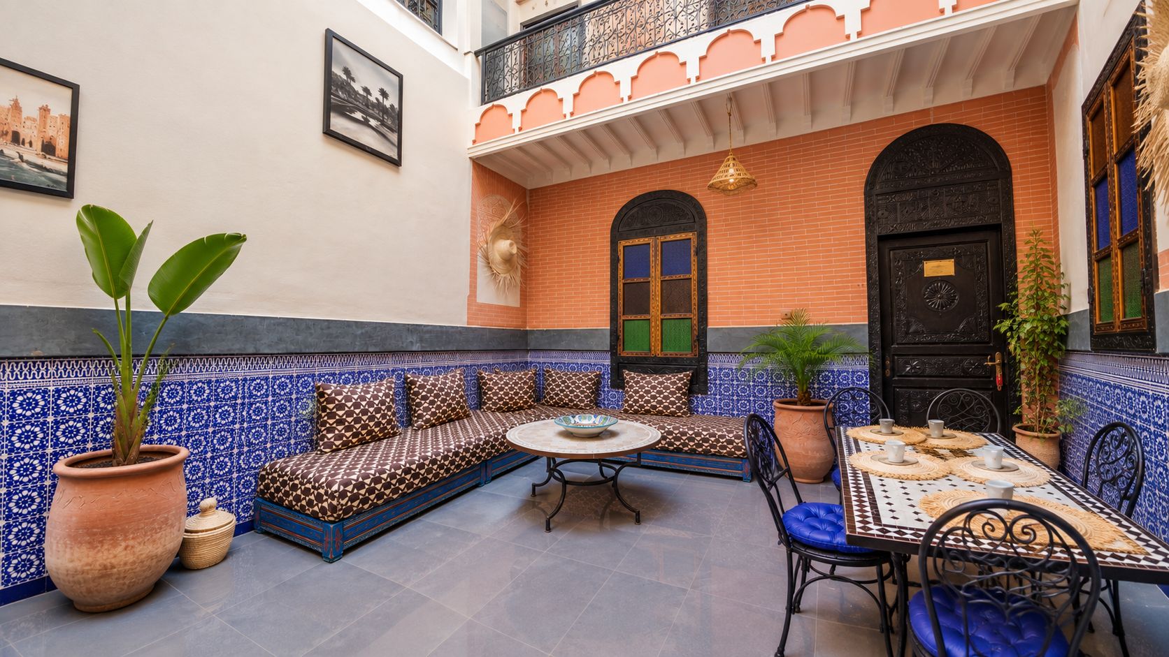 A courtyard with a seating area, a table, and a door.