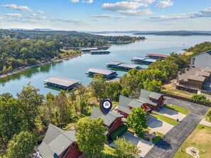 A lakeside property with multiple docked boats, a marina, and a mix of residential and commercial buildings.