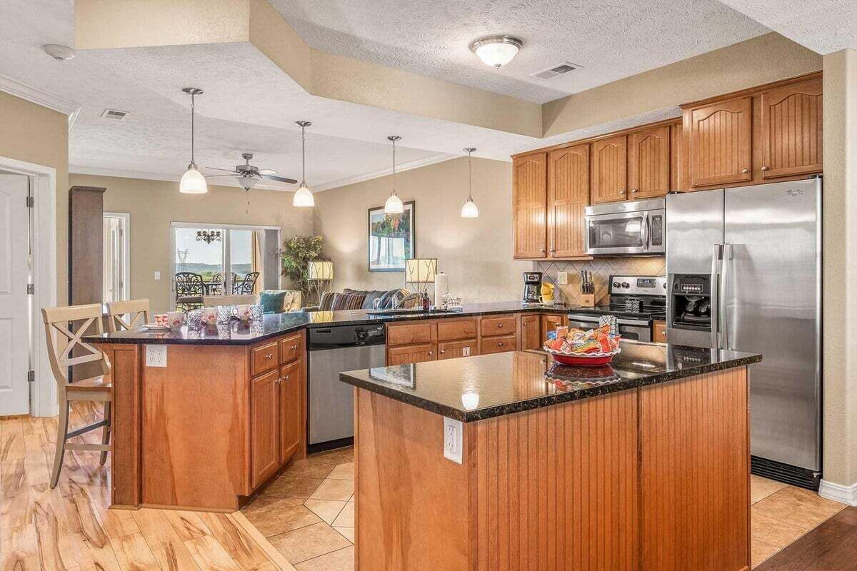 A spacious kitchen with wooden cabinets, stainless steel appliances, and pendant lighting.