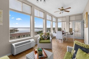 A spacious room with large windows, a ceiling fan, and a view of a body of water. - Luxury Majestic Condo on Table Rock Lake- Free Daily Attraction Tickets (Branson)