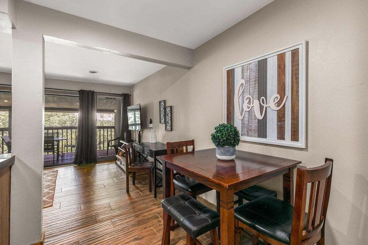 A dining area with a wooden table, chairs, and a potted plant.