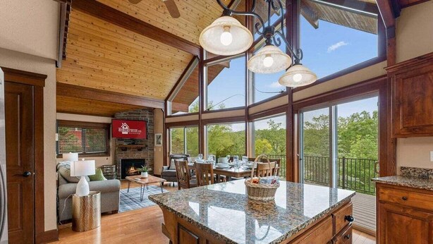 Una cocina amplia con una isla grande, armarios de madera y un comedor con chimenea.