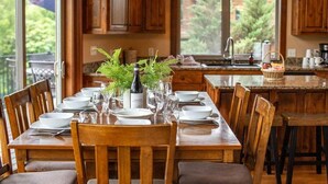 Un comedor con una mesa de madera dispuesta para una comida, rodeada de sillas de madera.