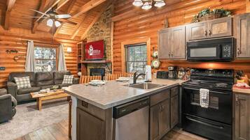 L’intérieur d’une cabane en rondins comprend une cuisine, un coin repas et un salon.