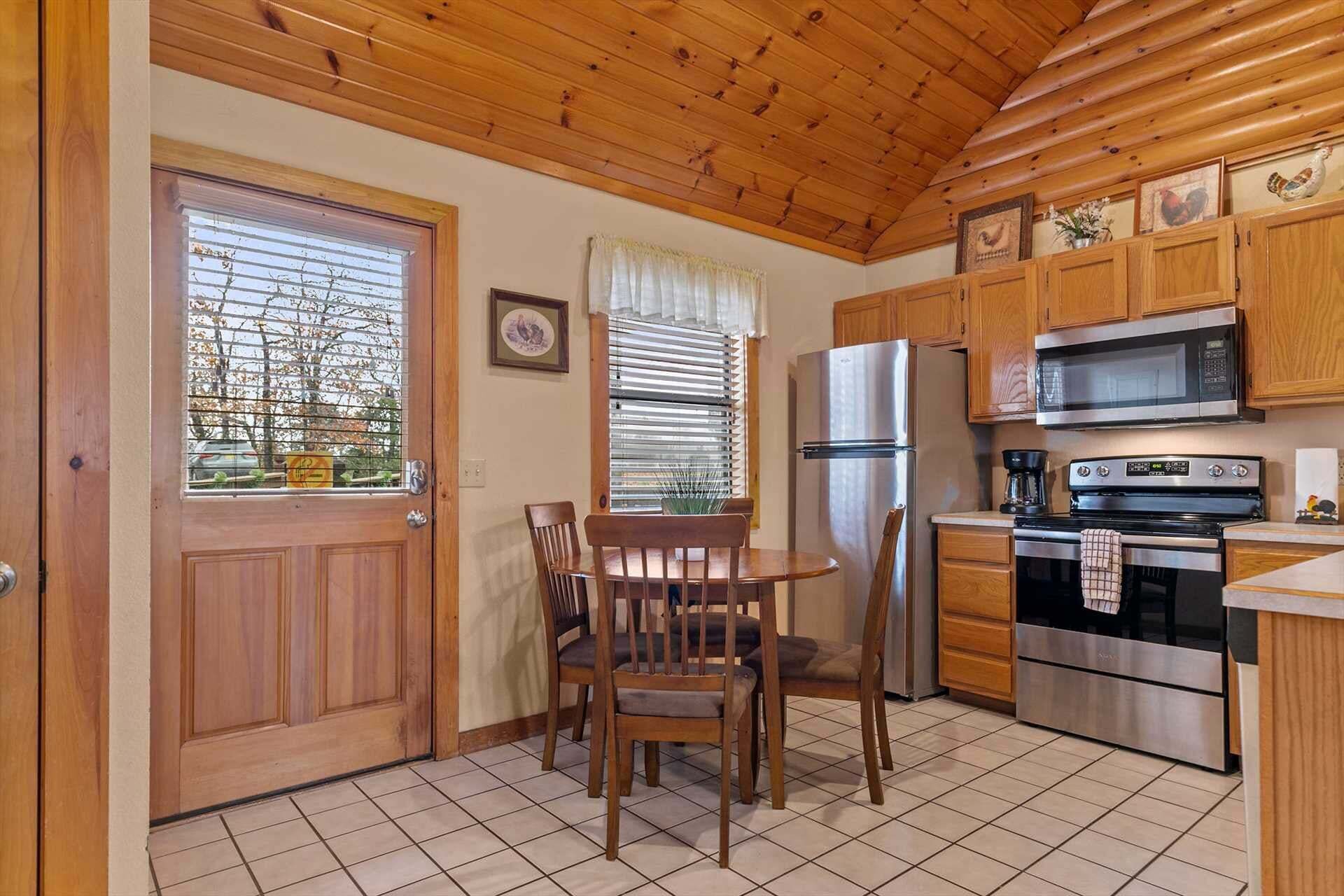 Una cocina funcional con armarios de madera, un refrigerador, un microondas y un horno.