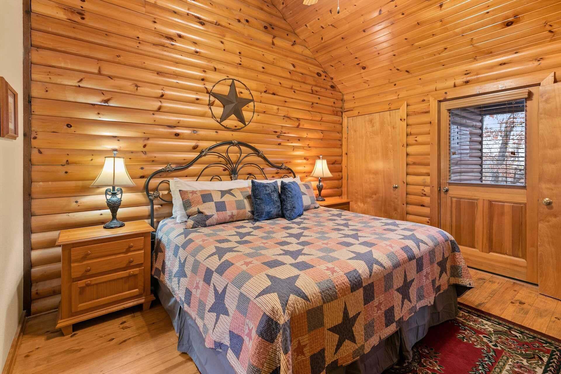 A wooden cabin bedroom with a bed, two bedside tables with lamps, a star decoration, and a window with blinds.