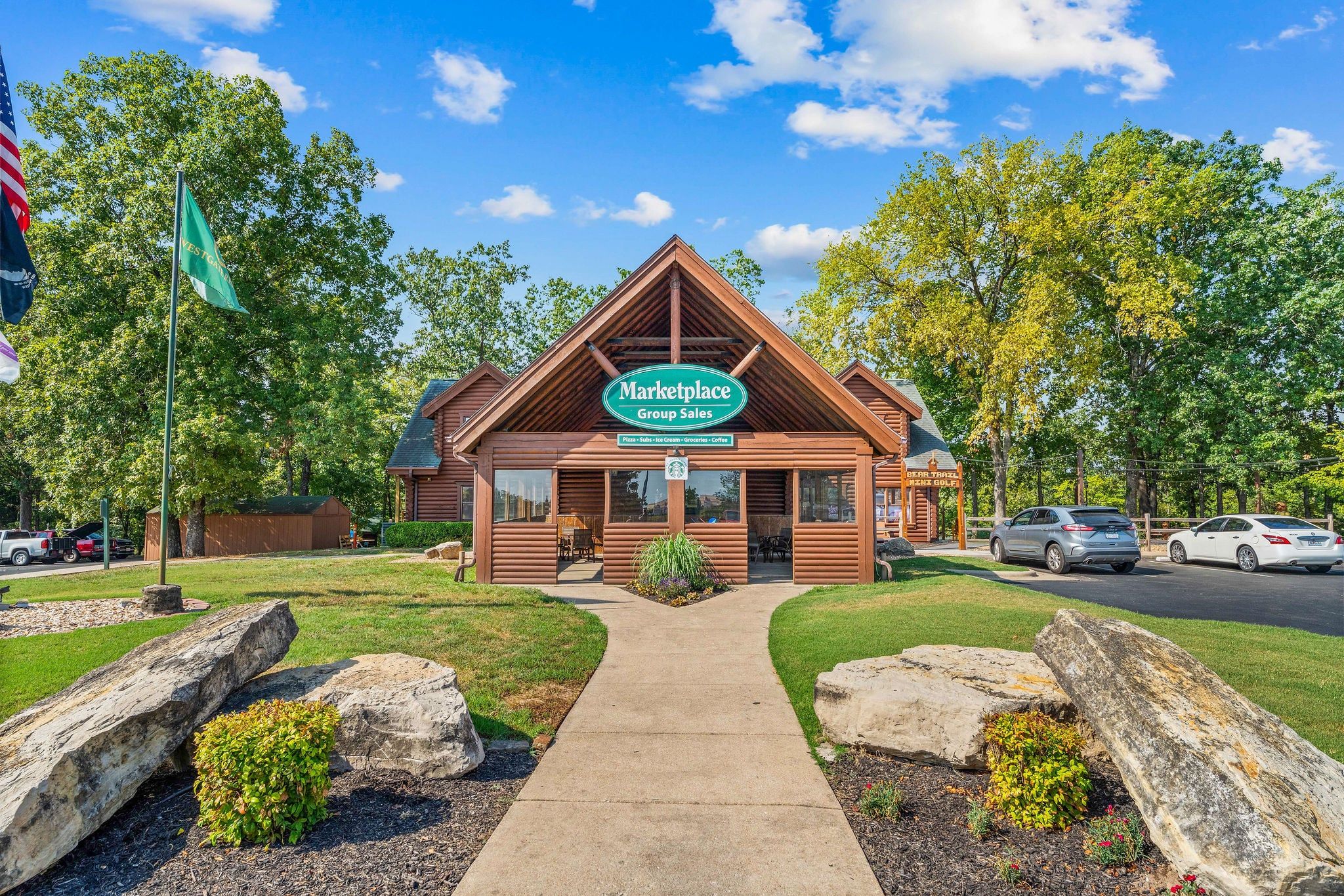 A Marketplace Group Sales building with a clear sky, surrounded by trees and a parking area.