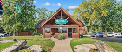 A Marketplace Group Sales building with a clear sky, surrounded by trees and a parking area.
