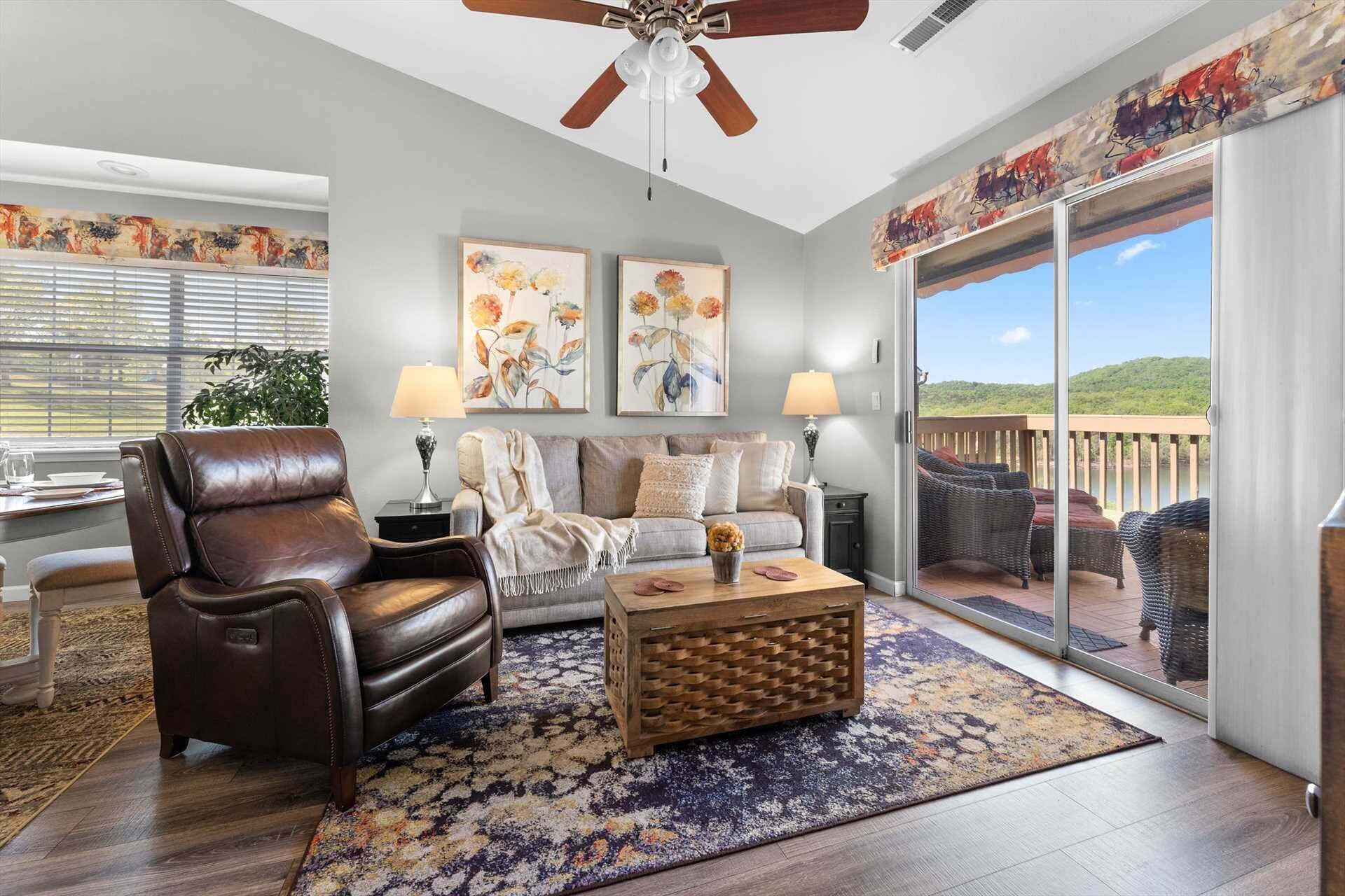 A living room with a leather sofa, a wooden coffee table, and a large window with a view of a balcony.
