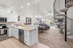 A modern kitchen with a central island, stainless steel appliances, and a dining area with a view to the living room. - Beautiful Condo, Free Daily Attraction Tickets-Close to Everything in Branson! (Branson)