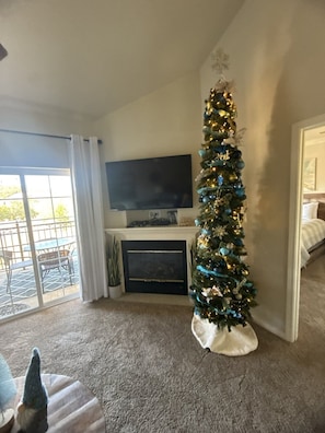 A living room with a Christmas tree, a flat-screen TV, and a fireplace. - Beautiful Condo, Free Daily Attraction Tickets-Close to Everything in Branson! (Branson)