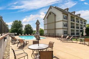 A poolside area with lounge chairs, a table, and umbrellas. - Beautiful Condo, Free Daily Attraction Tickets-Close to Everything in Branson! (Branson)