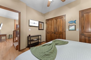 A bedroom with a bed, a TV, a wooden wardrobe, a desk with a chair, and a framed picture on the wall. - Walk to Table Rock - Beautiful Logcabin- Free Daily Attraction Tickets (Branson)