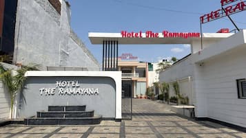 Hotel The Ramayana con una entrada despejada, un cartel y un camino pavimentado.