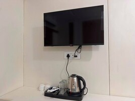 Televisor de pantalla plana montado en la pared, con un enchufe debajo.