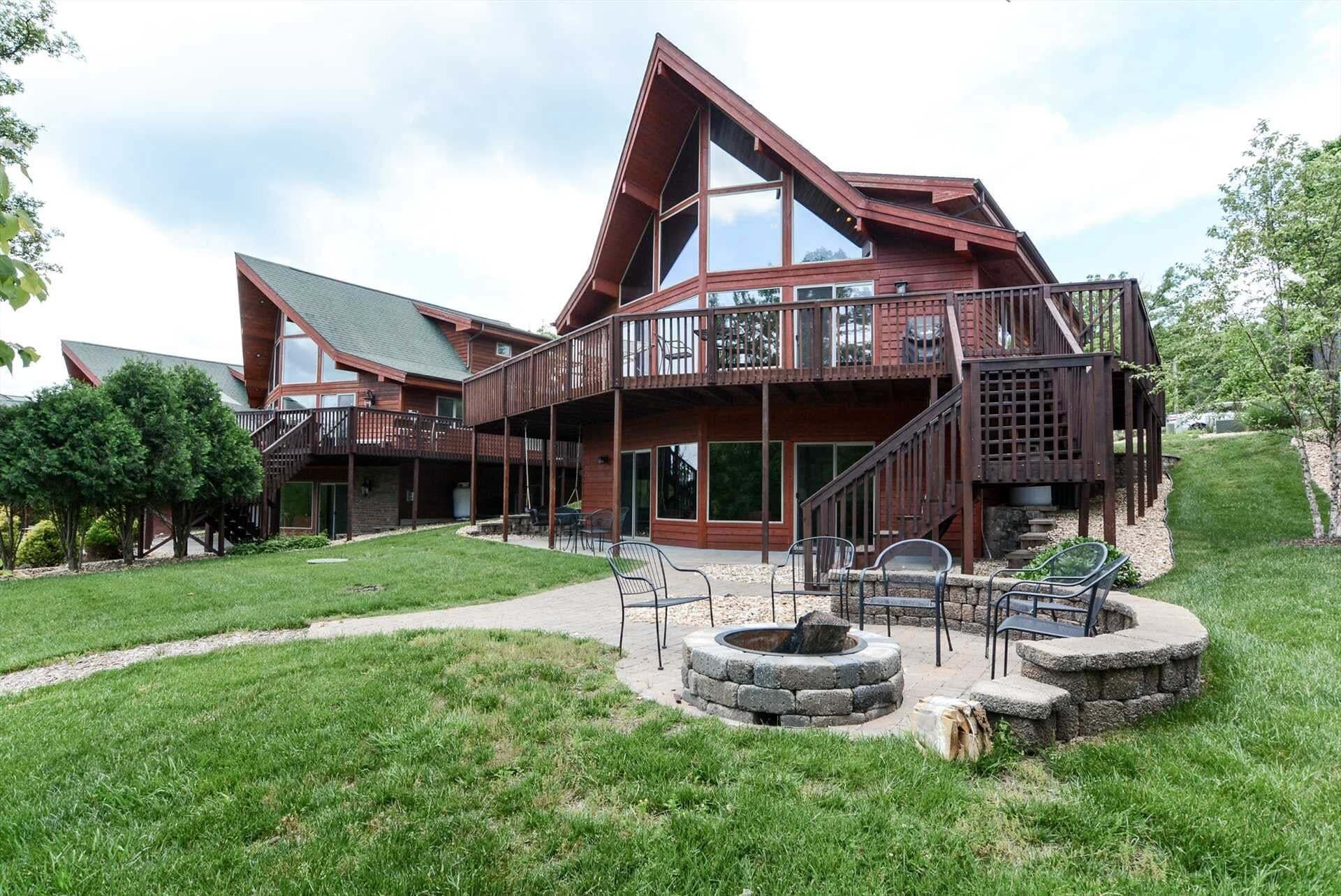 Eine große, mehrstöckige Holzhütte mit geräumiger Terrasse und Sitzbereich im Freien.