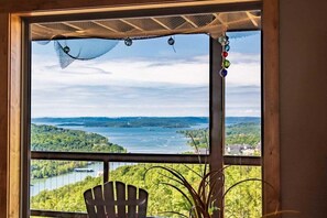 A room with a large window overlooking a lake and forested landscape. - Amazing Lake Views_Private Hot Tub_Community Amenities_Free Daily Attraction Tickets (Branson)