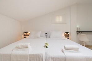 A double bed with white linens, two bedside tables with lamps, a chair, and a small table with a lamp. - New GR3 Penthouse Apartment in Downtown Málaga with a Cozy Terrace (Málaga)