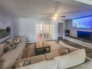 A living room with a sofa, coffee table, and a fireplace. - 5-Bedroom, 3-Bathroom Cozy Home (Warner Robins)