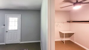 A room with a door, a ceiling fan, and a white table against the wall. - 5-Bedroom, 3-Bathroom Cozy Home (Warner Robins)
