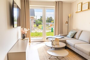 Una sala de estar moderna con un sofá, una mesa de centro y un televisor montado en la pared.