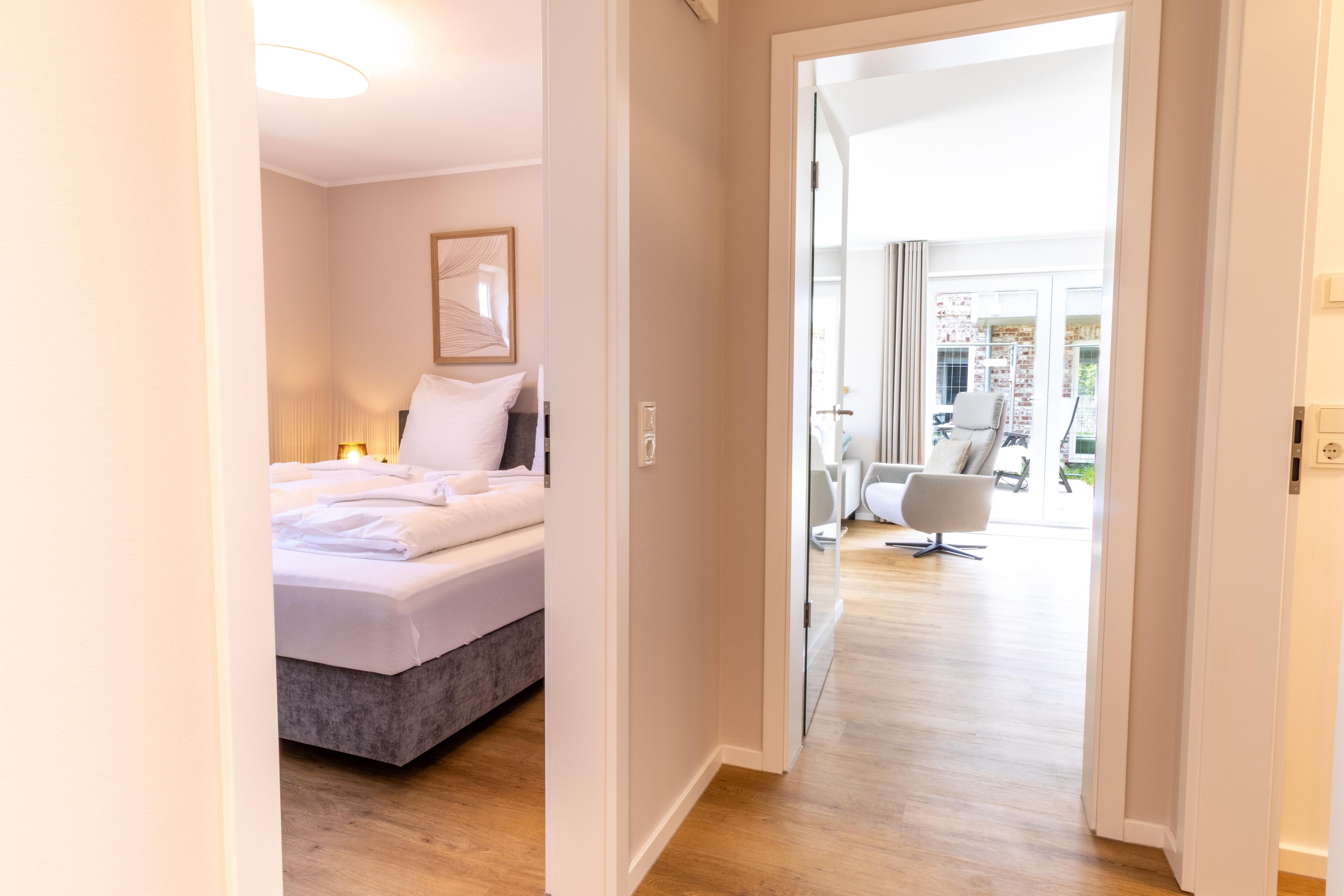 Una habitación de hotel con cama, mesita de noche, lámpara y vistas al exterior.