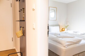 Una habitación de hotel con una cama, una mesita de noche con lámpara y un cuadro enmarcado en la pared.