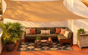 A corner seating area with a sofa, a coffee table, and a potted plant. - Quiet Apartment with Pool & Rooftop Terrace – Conil de la Frontera (Conil de la Frontera)