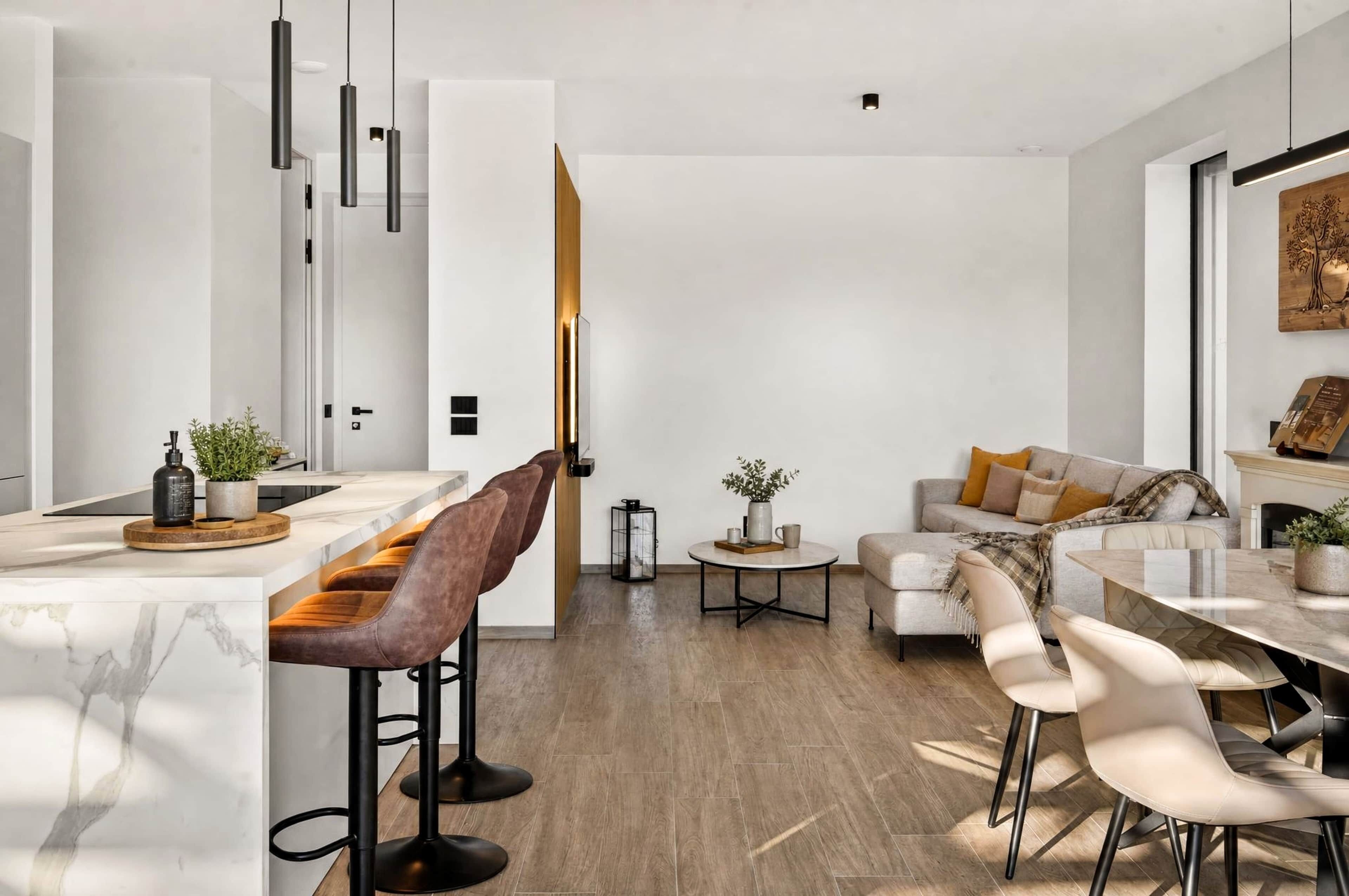 A modern living space with a kitchen, dining area, and seating area.