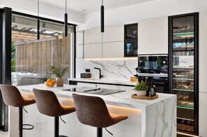 A modern kitchen with a marble countertop, black cabinets, and a built-in Bosch oven. - NEW: Casa Serenia - Residence Corte Carden 2 (Bardolino)