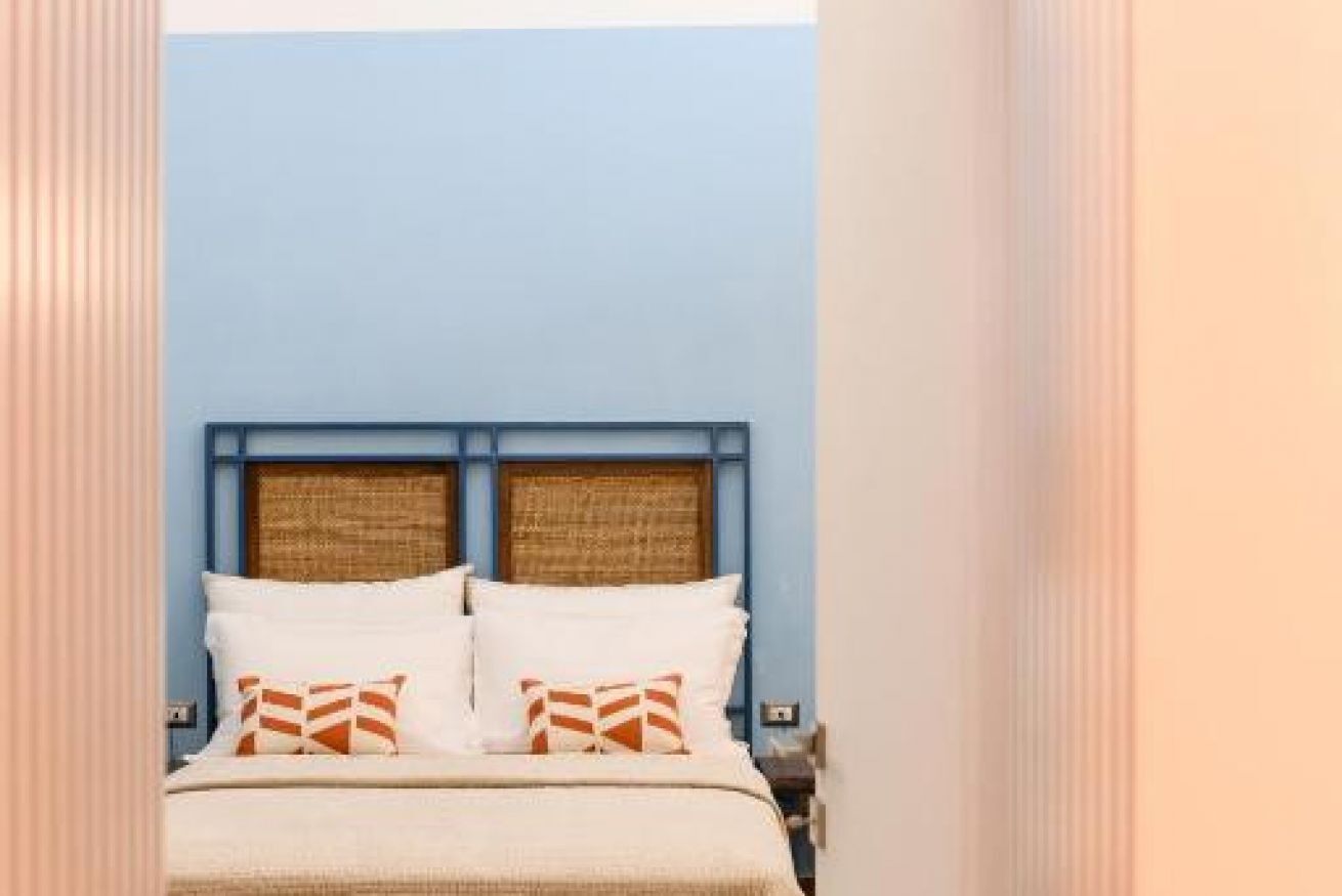 A bedroom with a bed, pillows, and a headboard.