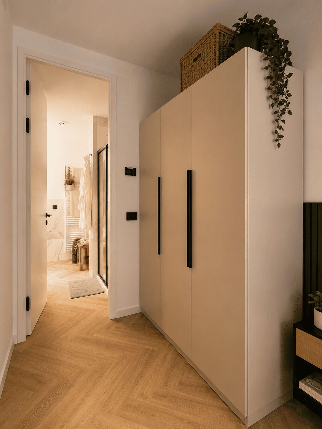 Un couloir avec une armoire, une plante et un panier posé sur le dessus.