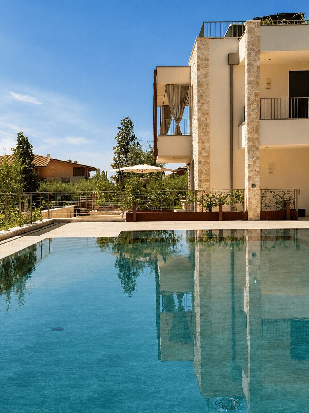 A clear swimming pool with a stone facade building in the background.
