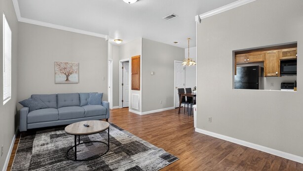 A modern living room with a grey sofa, a coffee table, and a patterned rug. - Relax and Feel at Home at Saddlebrook (Lumberton)