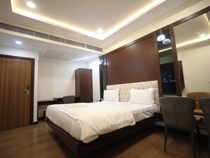 Una habitación de hotel moderna con una cama grande, un escritorio y una silla.