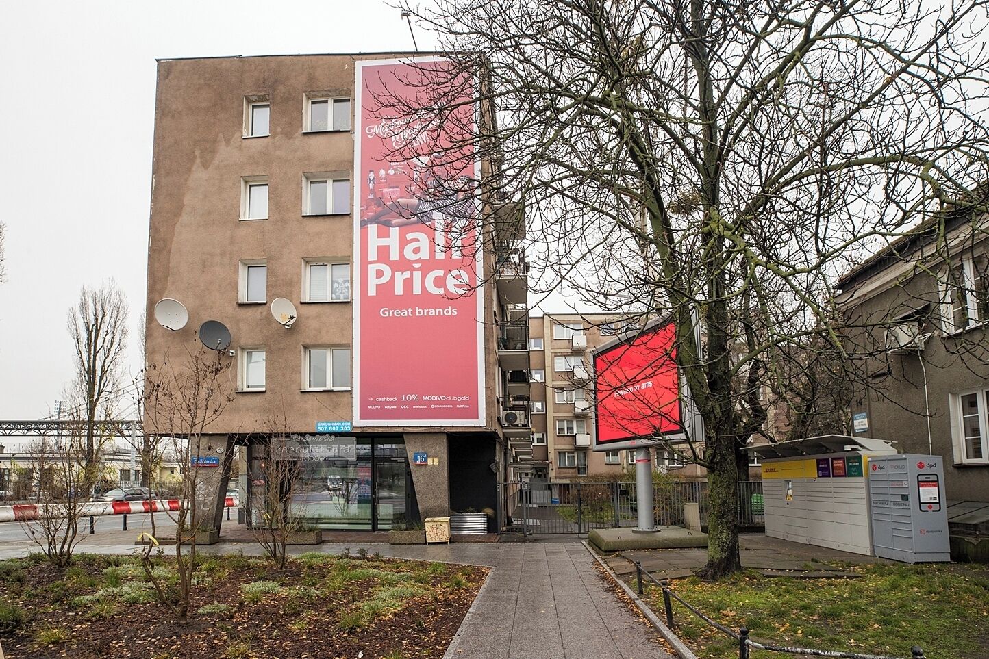 A building with a large red billboard advertising a sale.
