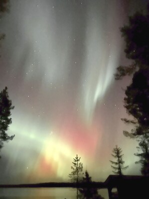 A night sky with visible stars and a faint aurora.