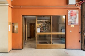 Ein Schaufenster mit Glastür, dahinter eine Holztür und ein Schild mit der Aufschrift 'SCALE A'.