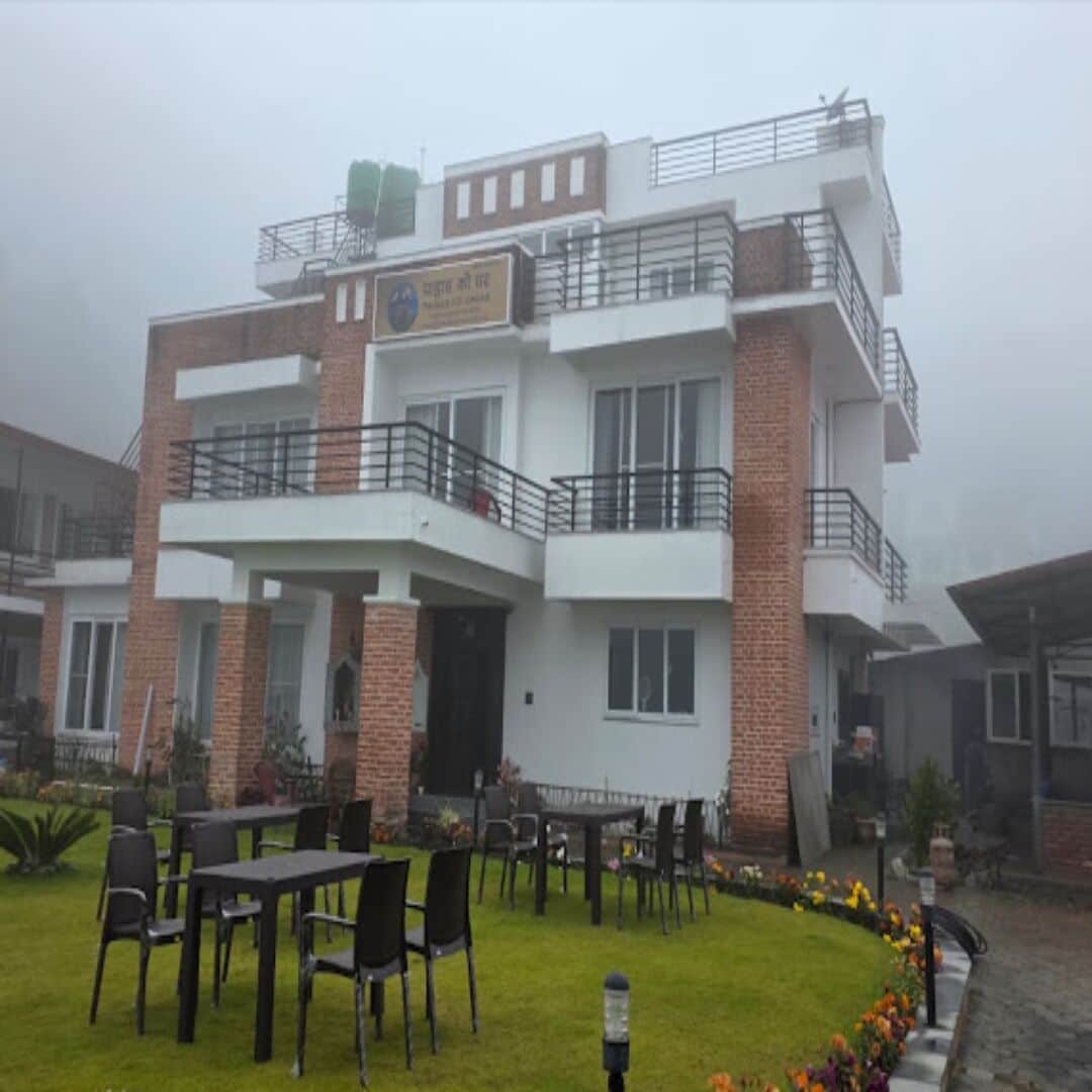 Un edificio de varios pisos con techo plano y un balcón en el nivel superior, y un letrero con texto.